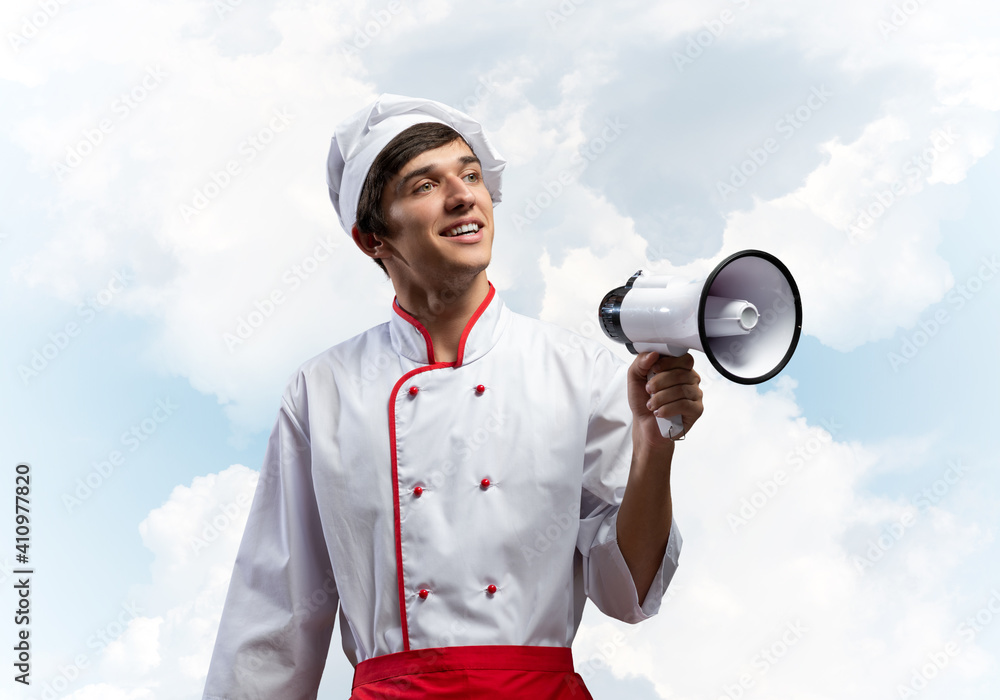 Young chef standing with megaphone in hand Young chef standing with megaphone in hand