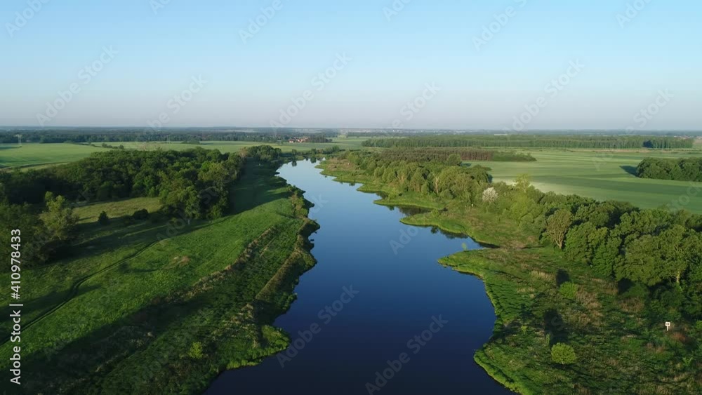 Odra river on a beautiful day. Dark blue water surrounded by green vegetation. A sunny day in the drone shot. Odra river on a beautiful day. Dark blue water surrounded by green vegetation. A sunny day in the drone shot.
