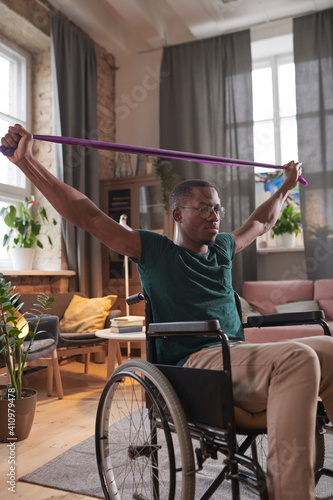 African young man working over his health he exercising during his rehabilitation while sitting in wheelchair