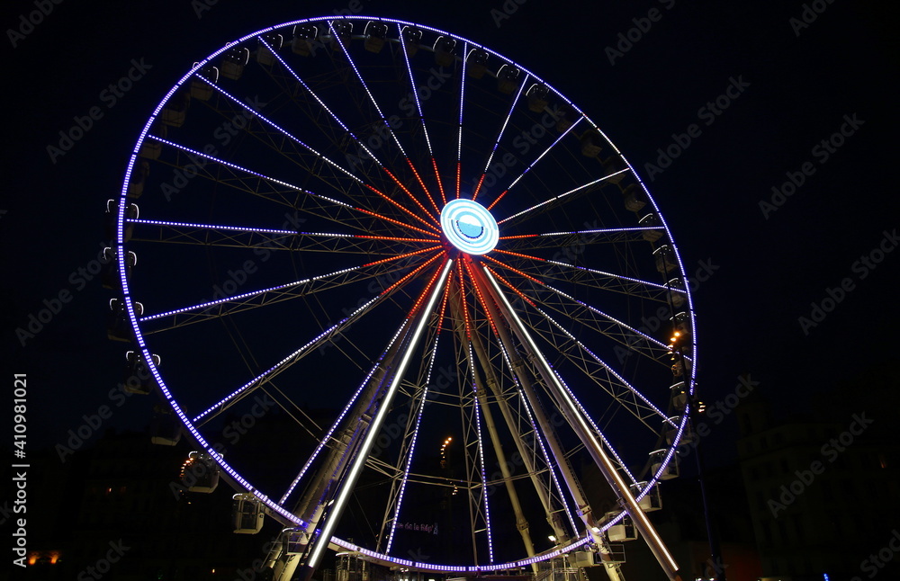 Night view from the bottom of the bright Grande Roue in the Vieux Port of Marseille, France