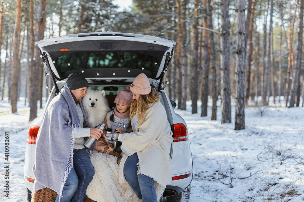Happy family with dog on vacation during the winter holidays