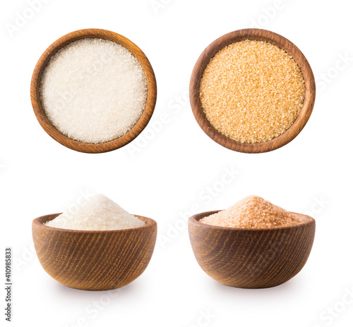 Heap of cane sugar and white sugar isolated on white background. Top view. Brown and white sugar isolation in different angles. Wooden bowl of dark sugar isolated on white background. Selective focus.