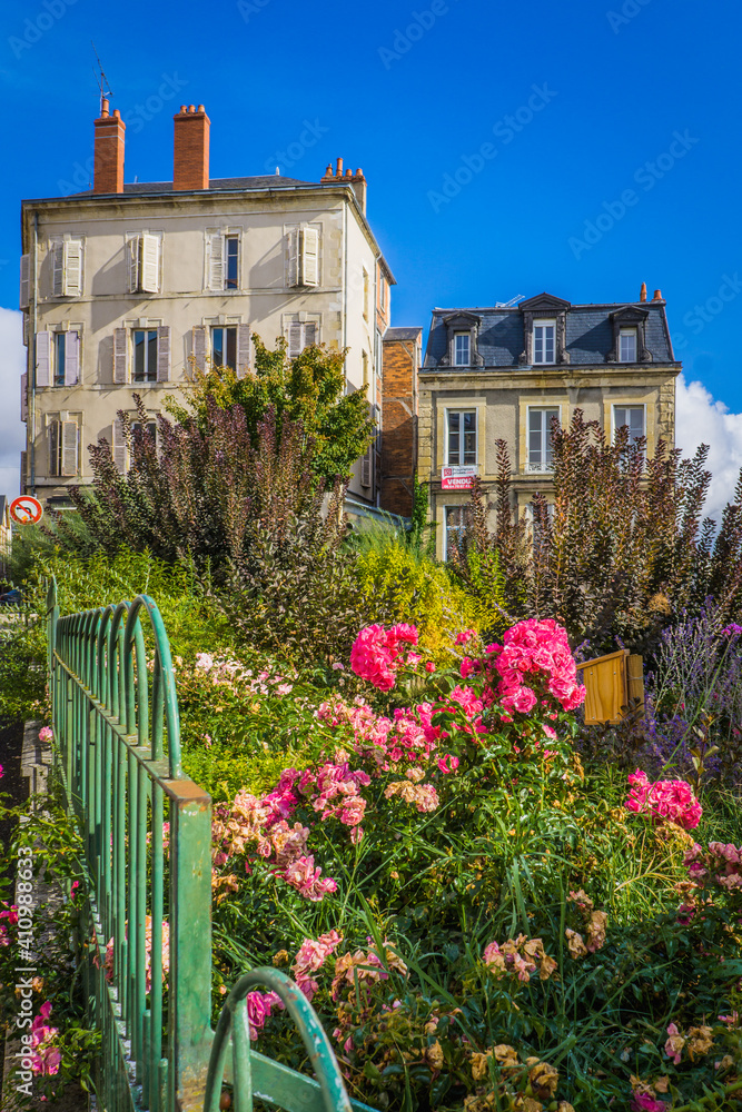 flowery garden with in the background typical early 20th century houses in the historic center of Nevers, located in Burgundy, France