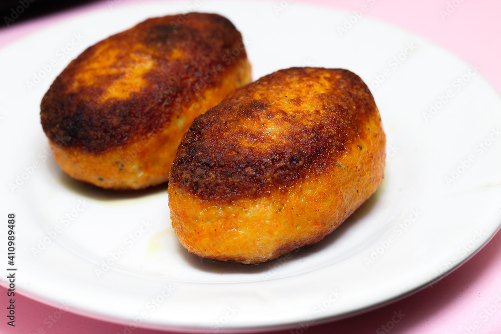 Burnt chicken cutlets, breaded on a white plate. Spoiled dish by a bad hostess. Burnt chicken cutlets, breaded on a white plate. Spoiled dish by a bad hostess.