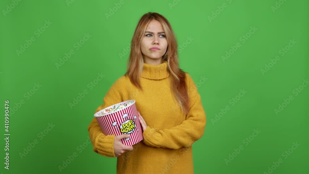 Teenager girl holding a bowl of popcorns having doubts and questioning an idea over isolated background Teenager girl holding a bowl of popcorns having doubts and questioning an idea over isolated background