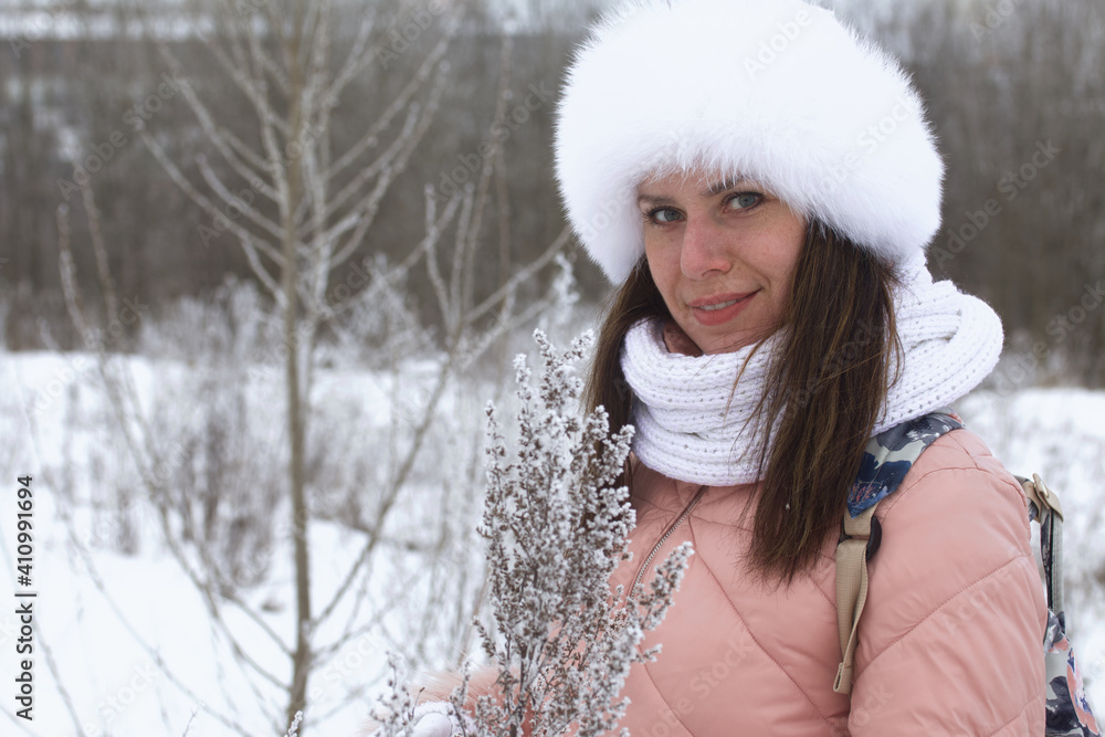 Portrait of a girl for a walk in a winter park. The plants are covered with frost and snow. Portrait of a girl for a walk in a winter park. The plants are covered with frost and snow.