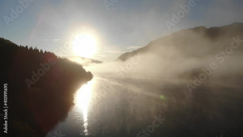 Aerial footage of the landscape showing a bright sunrise over Loch Cluanie near the Isle of Skye in the Scottish Highlands..Moving through the dense low lying cloud.. photo