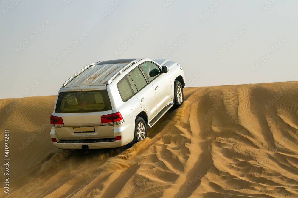 Driving on jeeps on the desert, traditional entertainment for tourists on in Pink Rock Desert, Sharjah, Dubai, UAE