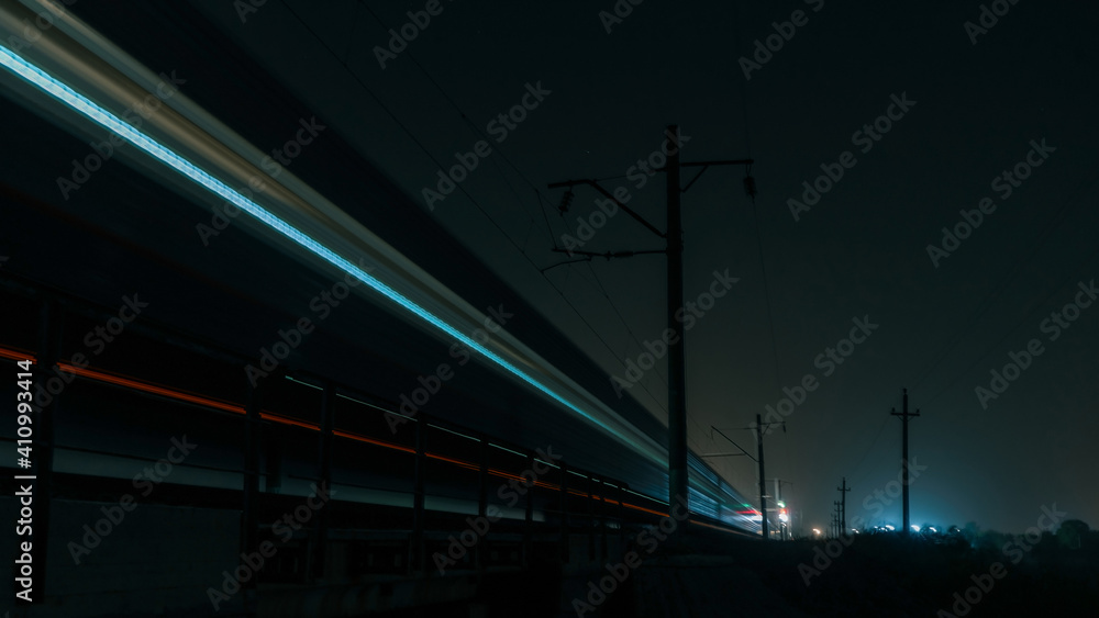 Obraz premium A train shot in motion at night. The train moves on the railroad into the distance. Blurred train.