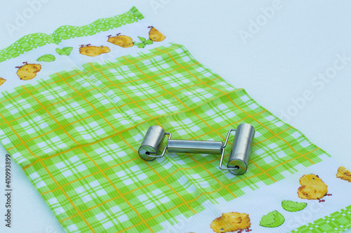 Rolling pin metal on the background of a white-green tablecloth.