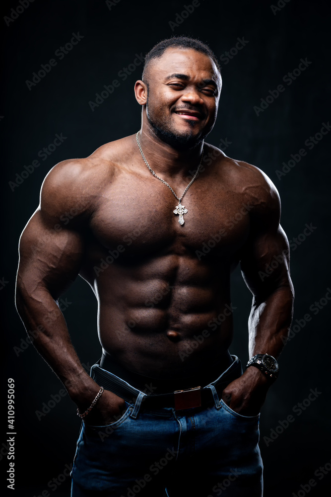Cool and muscular black young man with strong muscles. Portrait of an athletic african american looking at camera.
