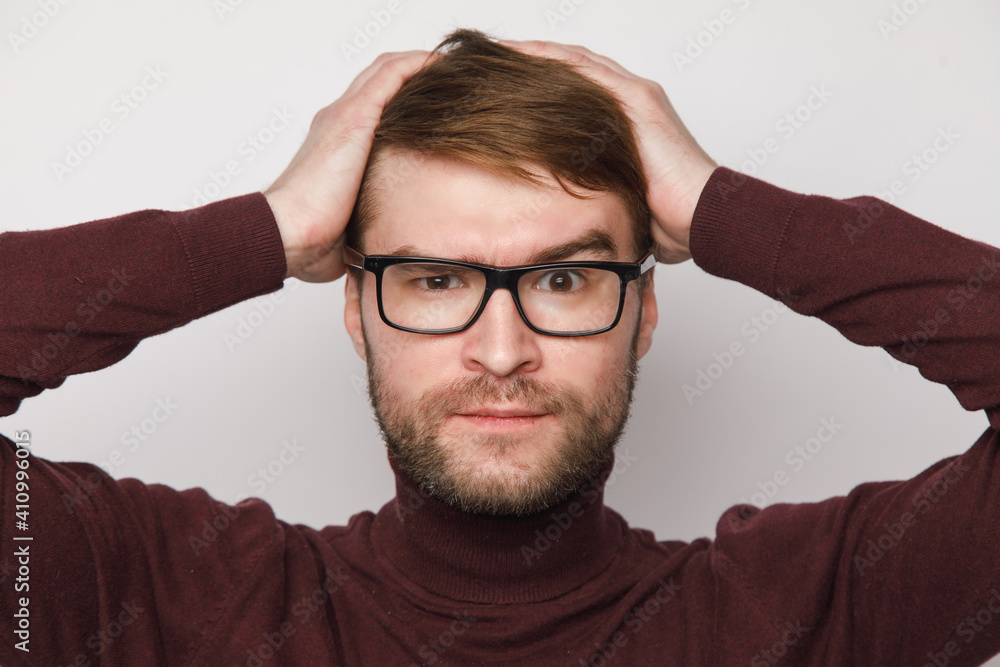 studio portrait of a frowning guy on a light background studio portrait of a frowning guy on a light background