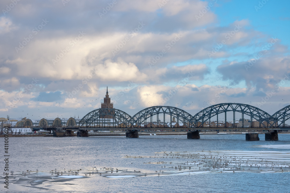 riga,panorama of the city, in the photo the city and the railway bridge,in the foreground the river and ice floes