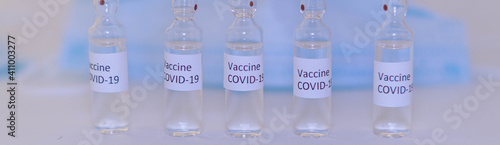 ampoules with Covid-19 vaccine on a laboratory on the table, syringe banner