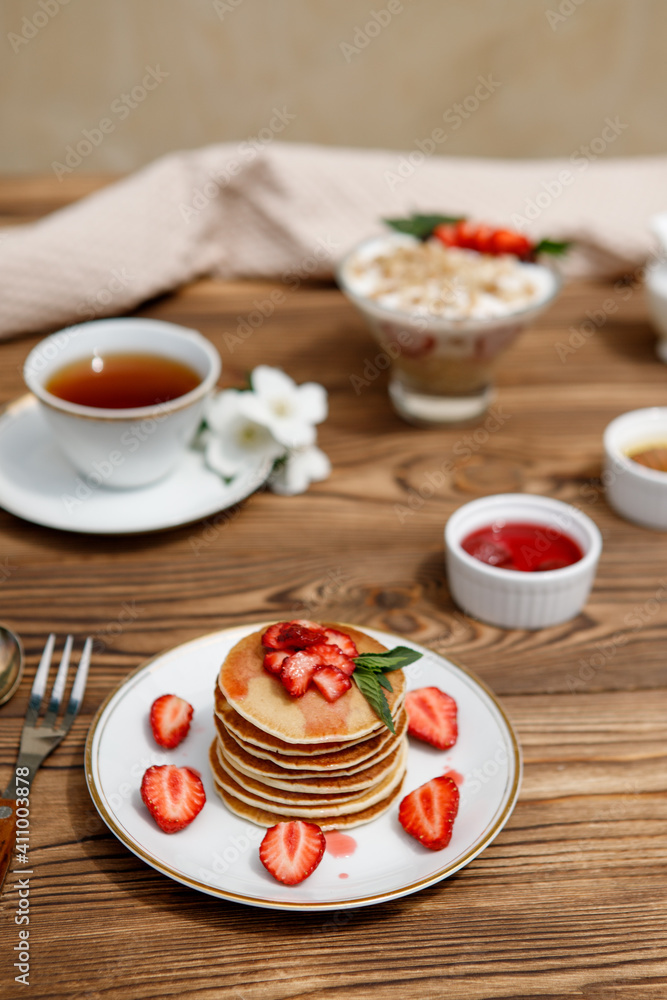 Healthy summer breakfast, homemade classic American pancakes with fresh berries and honey on a wooden background. Delicious pastries, dessert. Healthy summer breakfast, homemade classic American pancakes with fresh berries and honey on a wooden background. Delicious pastries, dessert.