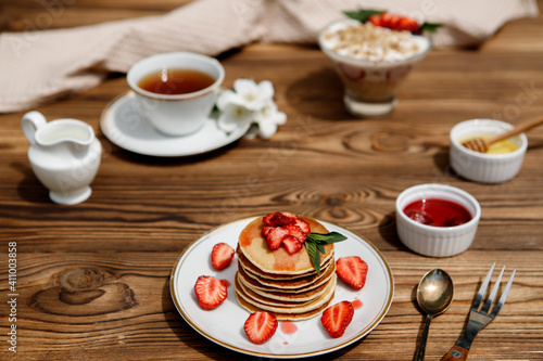 Healthy summer breakfast  homemade classic American pancakes with fresh berries and honey on a wooden background. Delicious pastries  dessert.