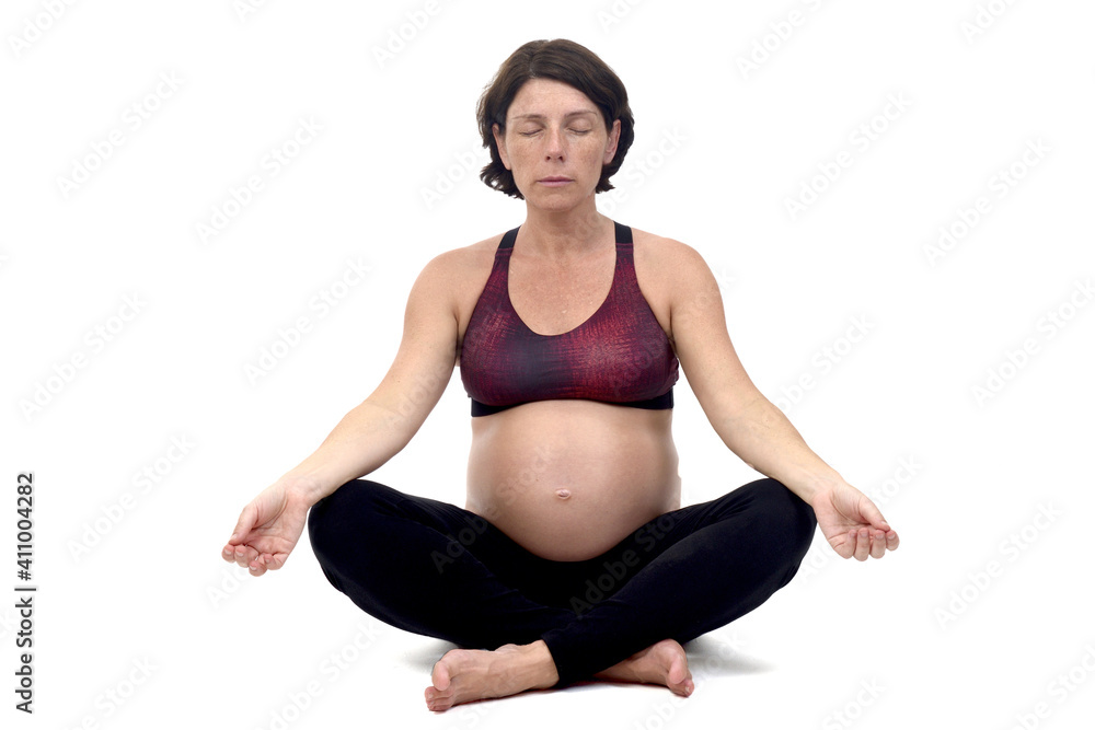 front view of apregnant woman doing floor exercises on white backgroun,sitting and eyes clossed front view of apregnant woman doing floor exercises on white backgroun,sitting and eyes clossed