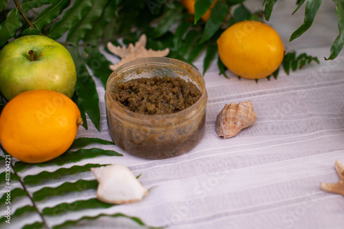 image of homemade cosmetics ingredients. aroma theme. organic cosmetics with extracts of herbs apples  lemons and oranges on white leaf green background