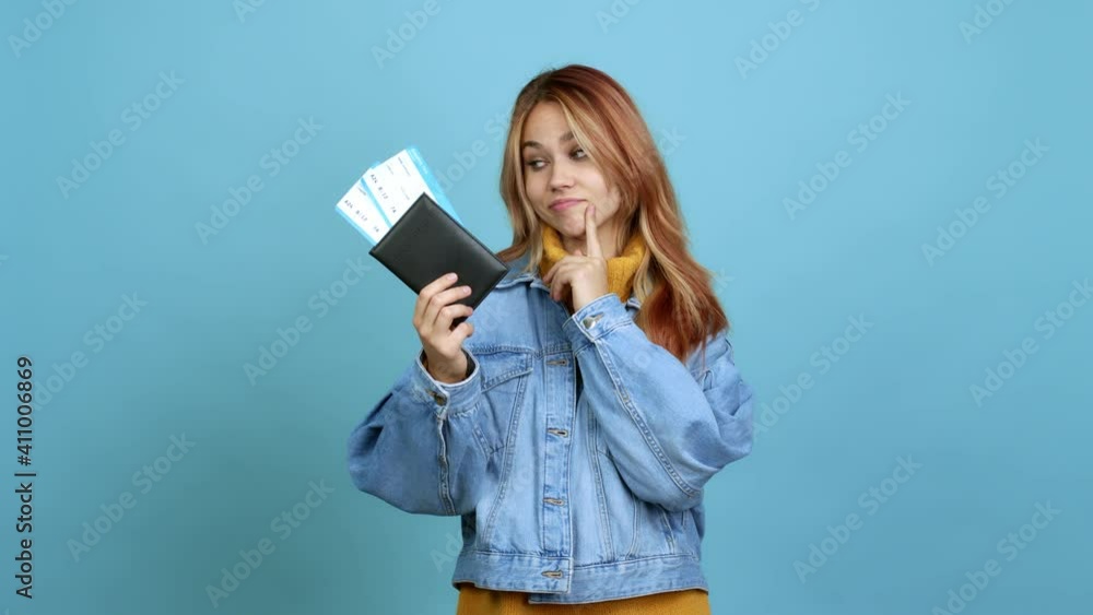 Teenager girl holding a passport standing and looking to the side over isolated background Teenager girl holding a passport standing and looking to the side over isolated background