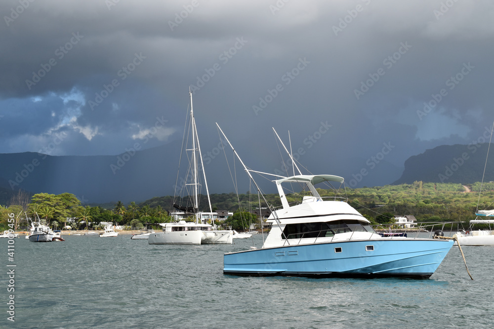 Mauritius dated 5th of Feb 2021. Leisure boats moored in a tranquil bay with in the background a terrible storm approaching.