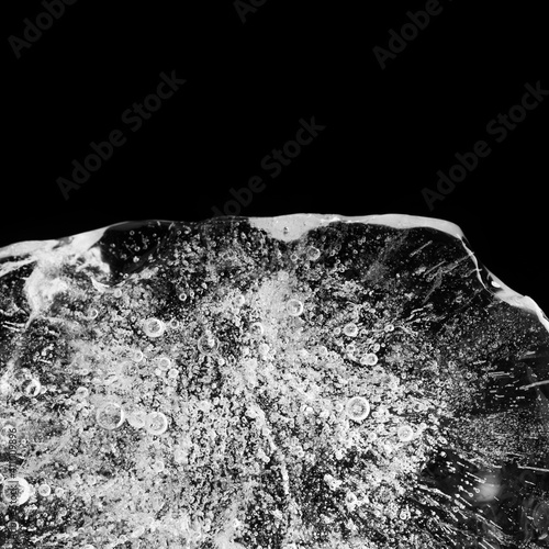 Abstract piece of ice floe with beautiful pattern and texture on black background. copy space