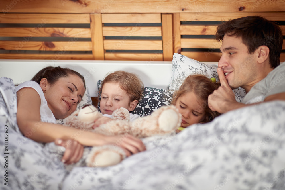 Young happy family sleeping in the bed together. Family, home, together