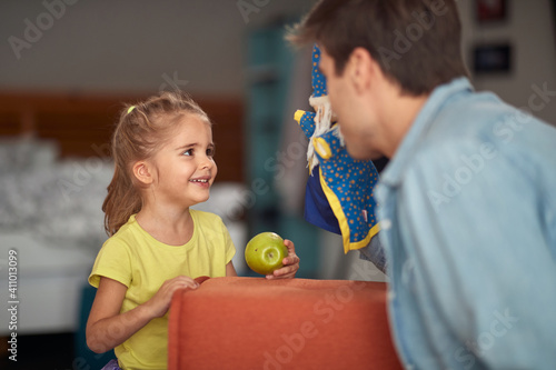 Cuadro en lienzo A little girl at home enjoying her father performance with a doll