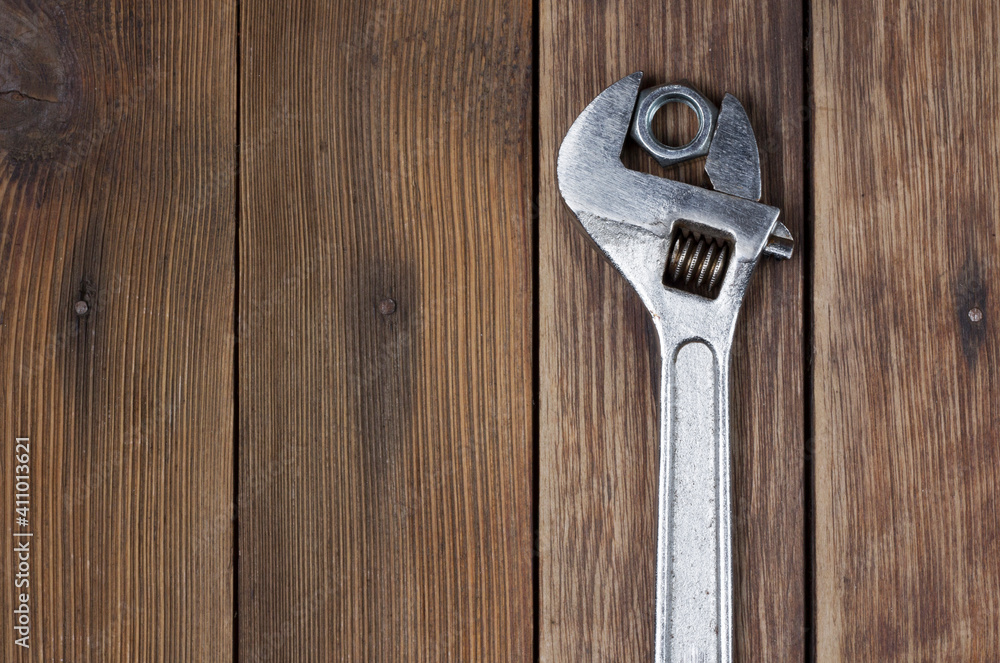 wrench and screw nut on a wooden background wrench and screw nut on a wooden background