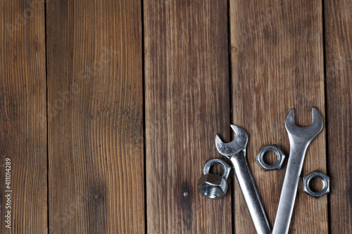 wrenches and screw nuts on a wooden textured background