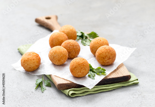 Quadro su tela Potato balls croquettes with parsley on a wooden board on a light gray backgroun