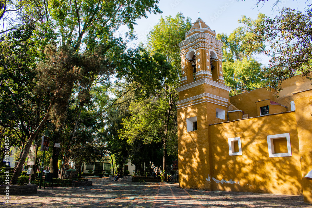 Naklejka premium Old Mexican Church surrounded by trees in Coyoacan