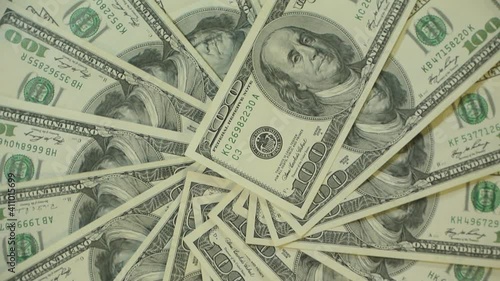 A lot of 100 dollar banknotes rotating in a seamless loop, in a close up shot from above, seamless video background for a money oriented website