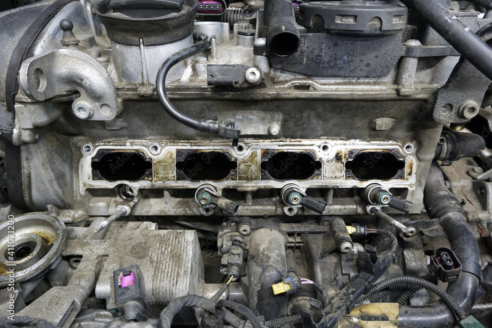 Fototapeta premium A partially disassembled engine of a modern car is ready for repair. The engine is dirty. Car service, spare parts.