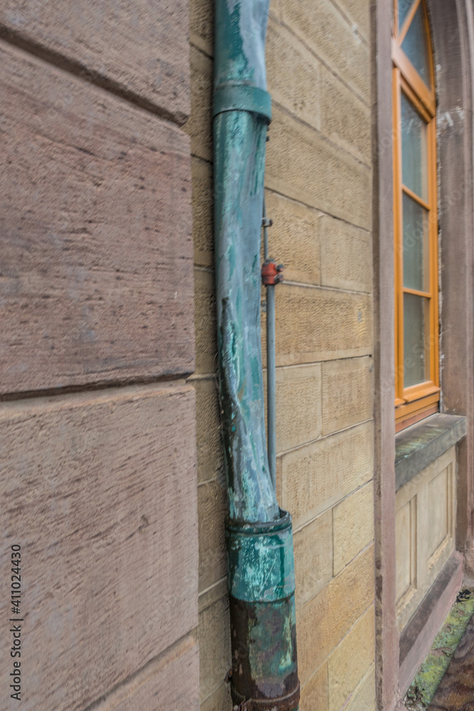 Defektes und oxidiertes Fallrohr aus Kupfer