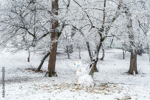 snowman with covid mask in the forest