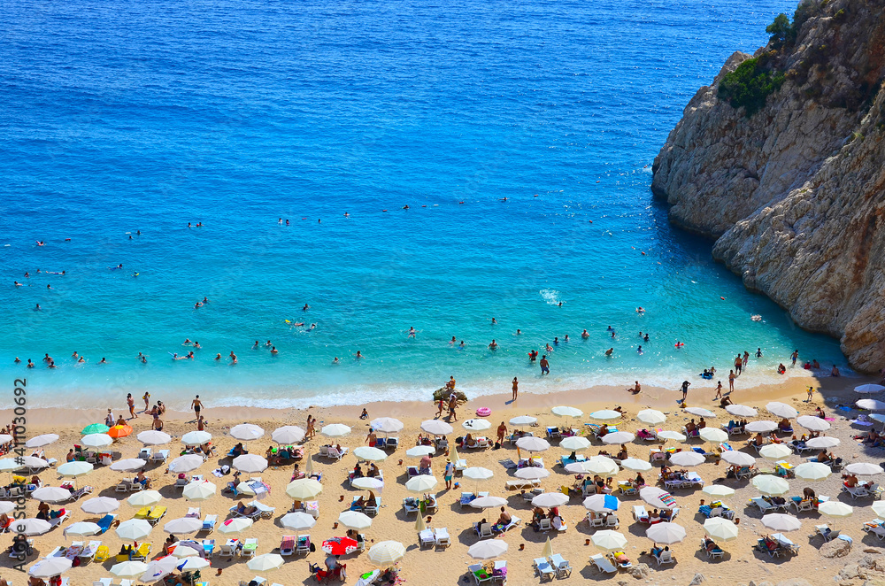 People swim in the azure sea and sunbathe on Kaputas beach in Turkey. Rocks, sea, sun People swim in the azure sea and sunbathe on Kaputas beach in Turkey. Rocks, sea, sun