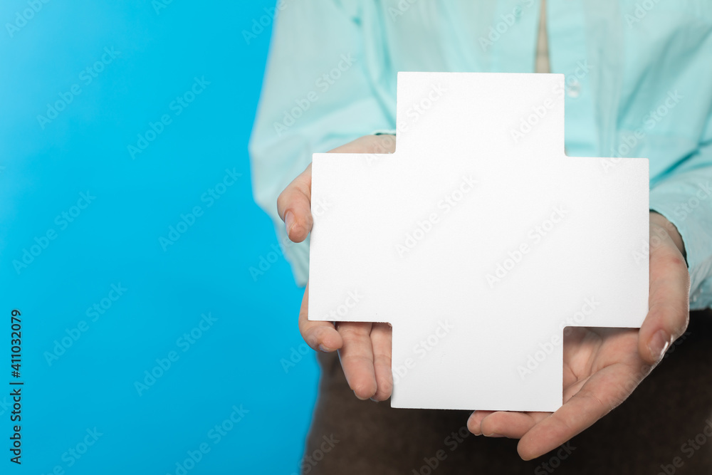 The girl holds a plus sign in her hands which means adding but also a cross and may mean health or humanitarian aid. The girl holds a plus sign in her hands which means adding but also a cross and may mean health or humanitarian aid.