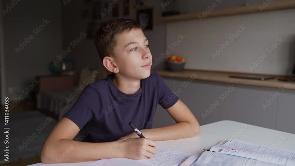 A schoolboy is learning lessons at home, a boy writing home task and schooling at home A schoolboy is learning lessons at home, a boy writing home task and schooling at home