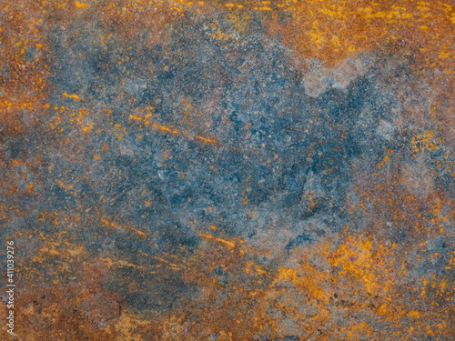 Metal plate with weathered colors and rust. Natural light. Blue and orange metal plate. Old oxidized colorful textured surface. Abstract grunge rusty metallic background for multiple uses. Corrosion.