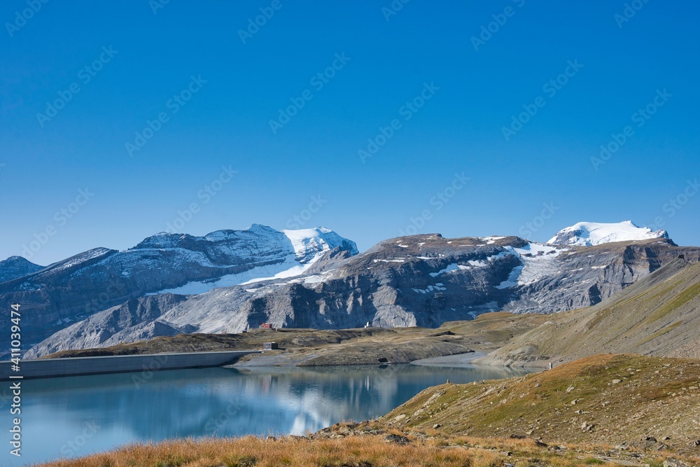 view of the muttsee reservoir surrounded by large snow mountains. Picture world famous Limmernsee, Glarus Switzerland
