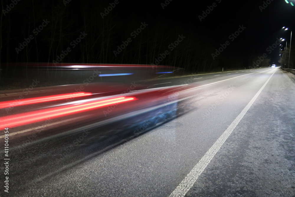 Fototapeta premium Car in motion on a road at night