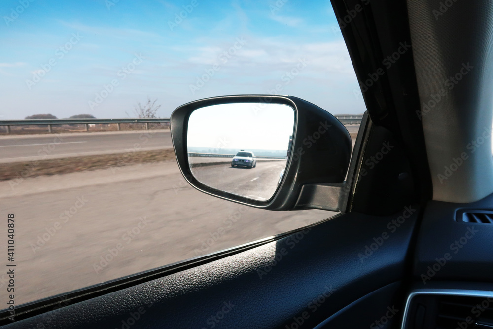 Car side-view mirror with other car in a reflection