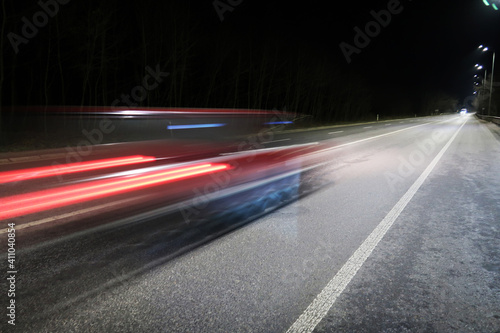 Car in motion on a road at night