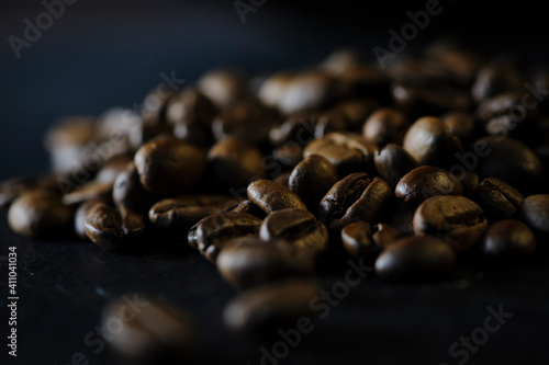 grains of black aromatic coffee. coffee beans on a dark background. the concept of a classic texture for drinking  taste and food. fragrant invigorating morning coffee  close-up