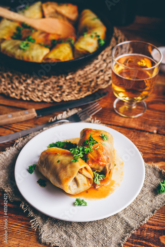 Portion of Cabbage Rolls Stuffed with Ground Meat on White Plate Served with Chopped Parsley