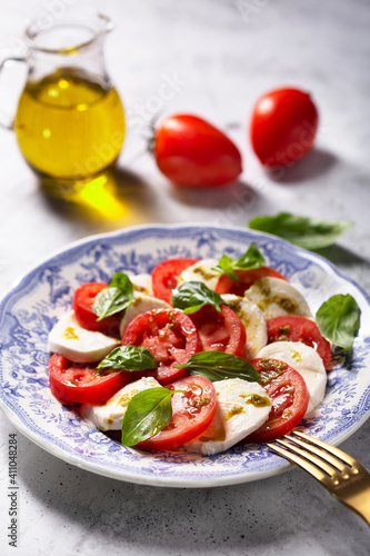 Caprese salad. Italian famous salad with fresh tomatoes, mozzarella cheese and basil