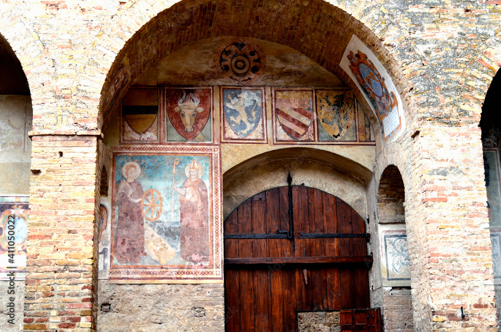 Archway with a Gate and Frescos on the Medieval Wal in San Gimignano Tuscany Italy
