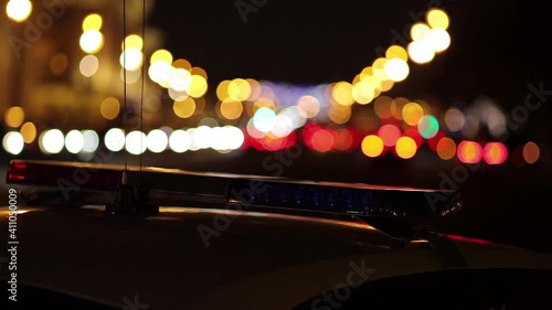 Emergency vehicle lighting - police car roof mounted strobe light - red and blue. Night city scene.