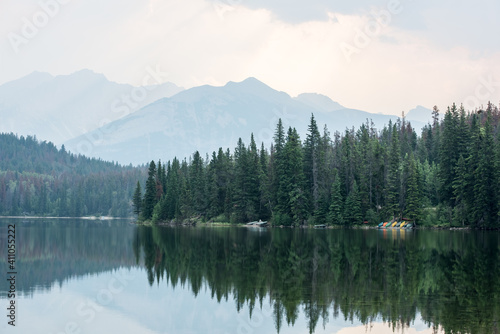 Waterscape in the Canadian Rockies with reflections of trees and mountains in the background.