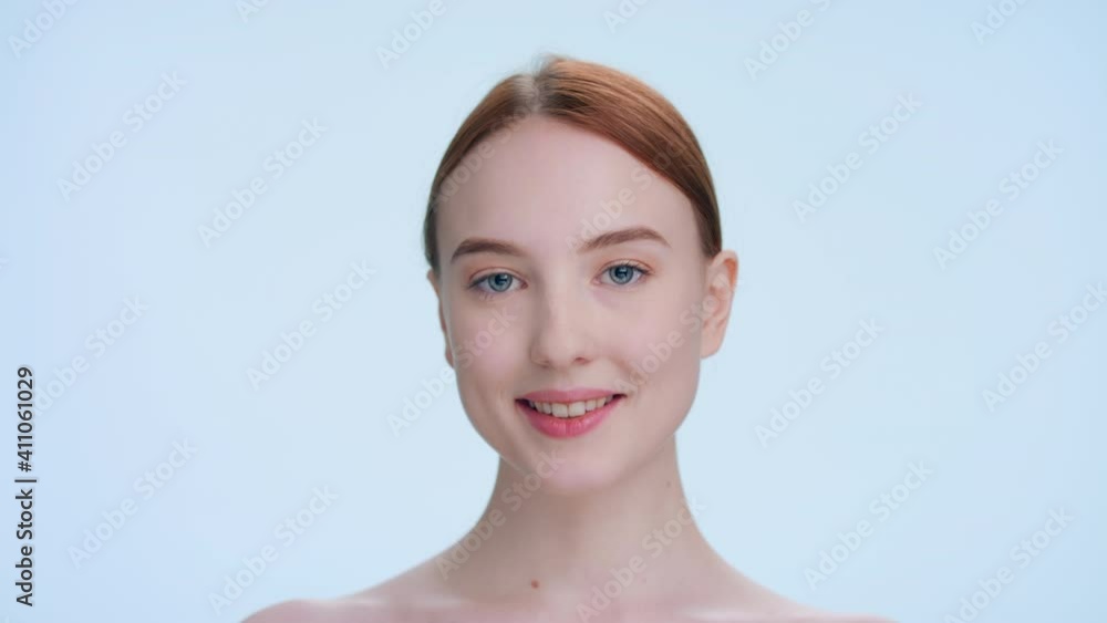 Young attractive ginger woman touches her face runs fingers from under her eyes up to her temples and down along her cheeks | Skincare products beauty portrait Young attractive ginger woman touches her face runs fingers from under her eyes up to her temples and down along her cheeks | Skincare products beauty portrait